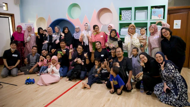 Foto sekelompok orang yang terdiri dari para ibu, ayah, dan anak-anak dalam kelas yang diorganisir oleh komunitas MotherHope Indonesia.