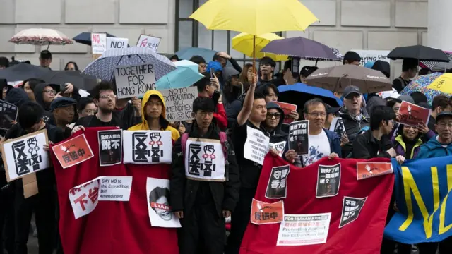 伦敦的示威者举起象征2014年雨伞运动的黄色雨伞。
