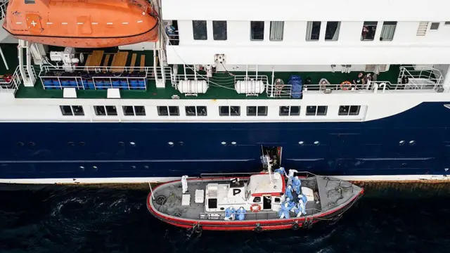Esta vista aérea muestra al personal sanitario ayudando a pacientes a subir a un bote desde el crucero MV Hondius, mientras se encontraba anclado frente al puerto de Praia, la capital de Cabo Verde, el 6 de mayo de 2026.