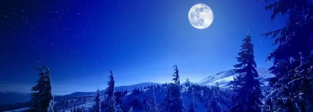 Snowy view of a full moon over the Carpathian Mountains.