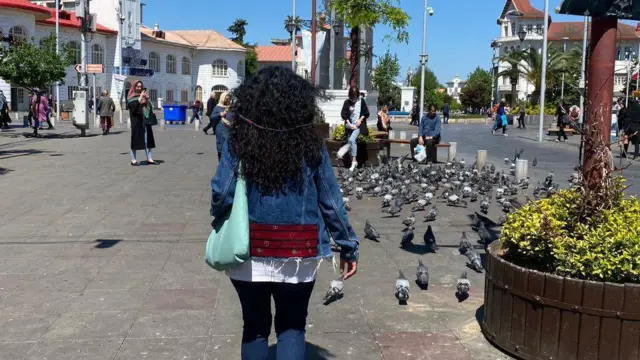 Une femme qui marche dans la rue, elle ne porte pas de foulard.