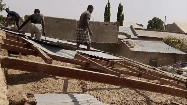 Men help remove roof of Mallam Saidu