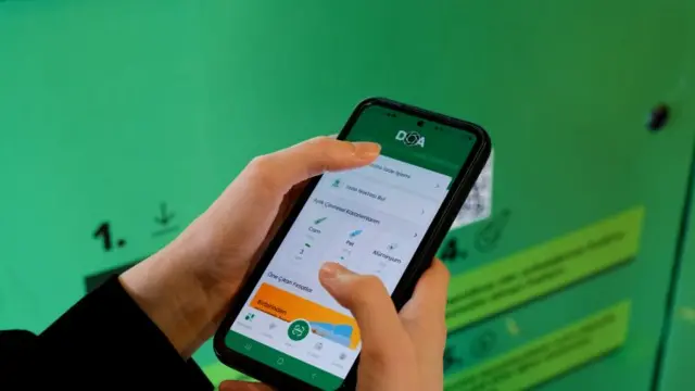 DOA uygulamasını indirmiş bir genç telefonuna bakıyor 