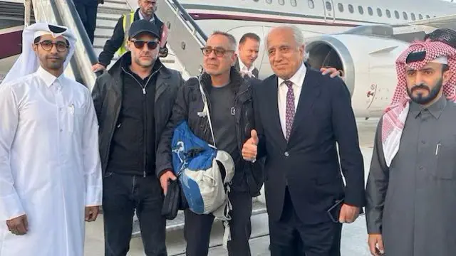 زلمی خلیلزاد له یوه امریکایي وګړي سره، چې تر دوه کلونو وروسته د طالبانو له زندانه خوشې شو