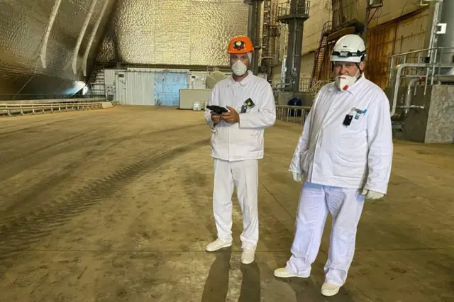 Doroshenko de pé, ao lado de um companheiro de trabalho, dentro do domo que protege o reator 4 da usina nuclear de Chernobyl