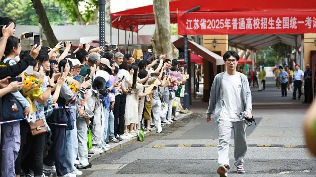 Phụ huynh đứng dọc hai bên đường để chào đón các em học sinh vừa hoàn thành kỳ thi đại học tại Nam Kinh, tỉnh Giang Tô