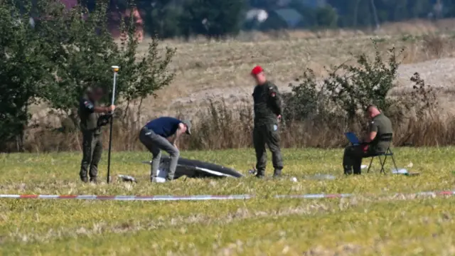 Представители польских властей осмаривают обломки дрона