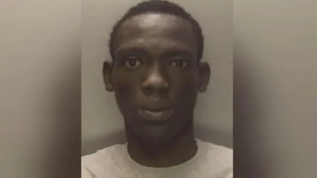 Deng is wearing a grey top in a police mugshot. He has short dark hair.