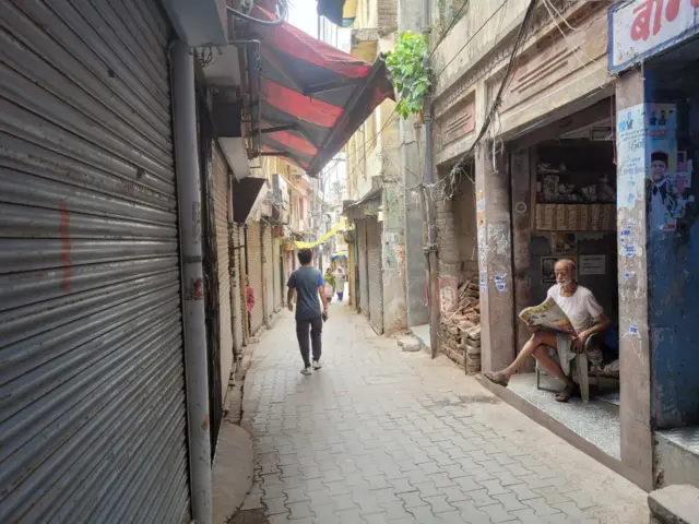 एक वृद्ध माणूस वर्तमानपत्र वाचत आहे