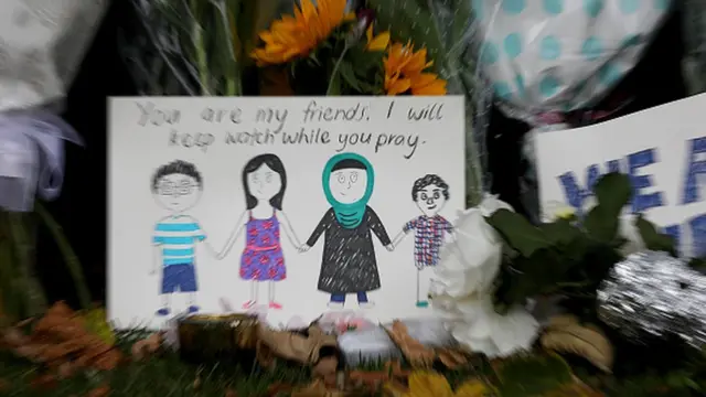 Çiçeklerin arasına bırakılan resimde "Siz benim arkadaşlarımsınız. Siz ibadet ederken ben nöbet tutacağım" yazıyor.