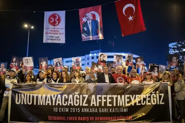 تجمع مردم در حالیکه بنر بزرگی در دست گرفتهاند که نوشتهای به زبان ترکی روی آن دیده میشود