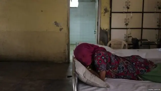 ਬੈਡ ਉੱਪਰ ਪਈ ਇੱਕ ਔਰਤ