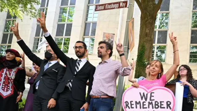 Wanaharakati wamesimama kando ya "Khashoggi Way", wakiwa na ishara kama ukumbusho wa mauaji ya Jamal Khashoggi.