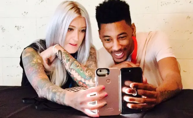 Pareja mirando sus smartphones.