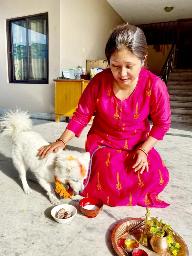 आज यामपञ्चकको दोस्रो दिन बुधबार कुकुर तिहार अर्थात् नरक चतुर्दशीमा कुकुरलाई पूजा गर्दै पोखरा- ८ न्युरोडकी व्यवसायी महिला सबी शेरचन ।