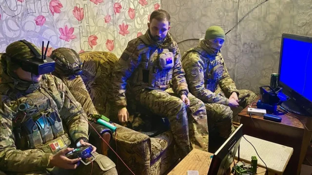 Des soldats enfilent des casques pour piloter des drones FPV depuis un bâtiment sur la rive ouest du Dnipro