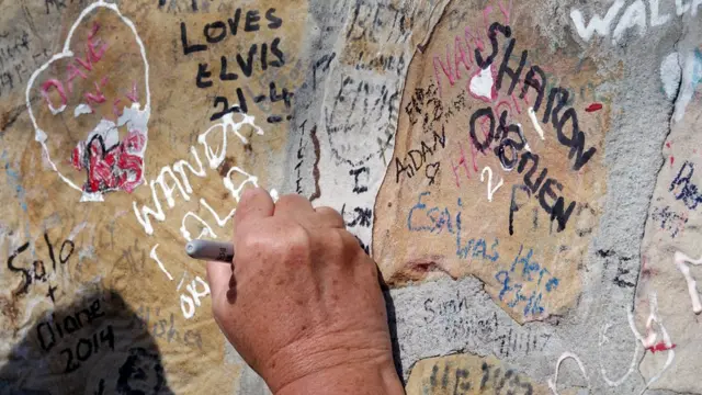 مازال محبو إلفيس بريسلي يعربون عن حبهم وإخلاصهم لفنه بكتابة كلمات تأبين وإعجاب على جدار في غريسلاند.