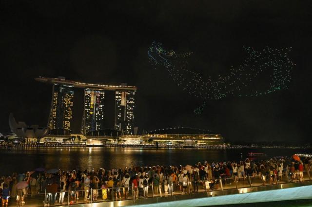 Жители Сингапура смотрят шоу, которое называется «Легенда о Воротах Дракона»