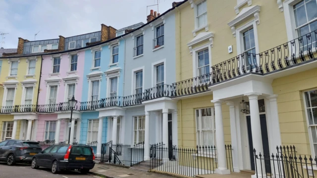 Uma fileira7games aplicativo para baixar ocasas coloridas na rua Chalcot Crescent, no bairro Primrose Hill,7games aplicativo para baixar oLondres. São casas amarelas, rosas, azuis e cinzas com quatro ou cinco andares. Há dois carros pretos estacionados na rua