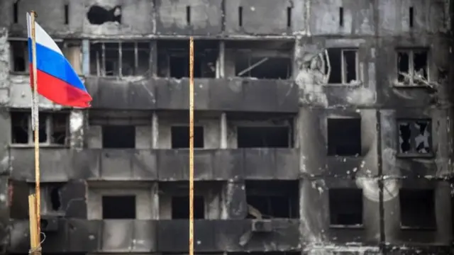 Орусиянын желеги, артында атлкаланган имарат