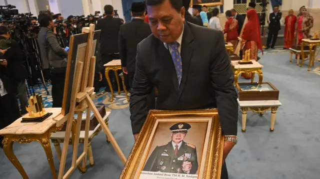 Petugas membawa foto Presiden kedua RI Soeharto usai prosesi upacara pemberian gelar pahlawan di Istana Negara, Jakarta, Senin (10/11/2025).