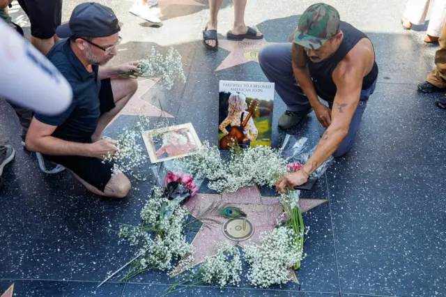 Fans ponen flores en la estrella de Dolly Parotn en el Paseo de la Fama de Hollywood.