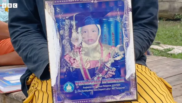 Ahmad memegang fotonya saat masih kecil