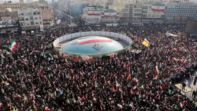 bir meydanda toplanmış kalabalıklar ve ellerinde pankartlar var