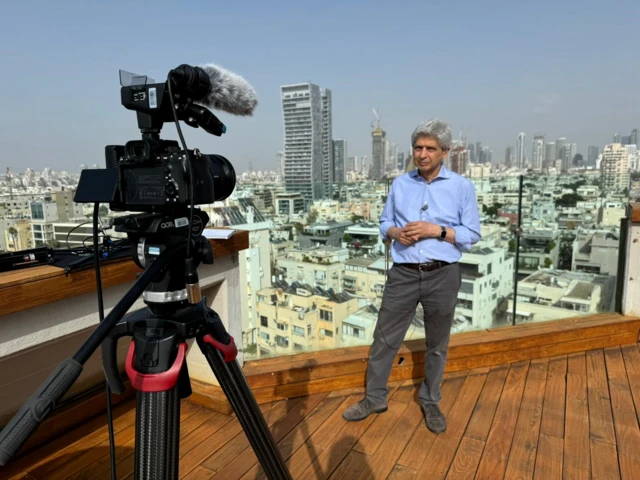 کسری ناجی در حال پخش زنده از پشت بام هتلی در اسرائیل