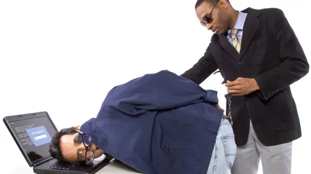 Hombre vestido de negro detiene a un hacker.