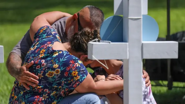 Mourners visit a memorial for the victims