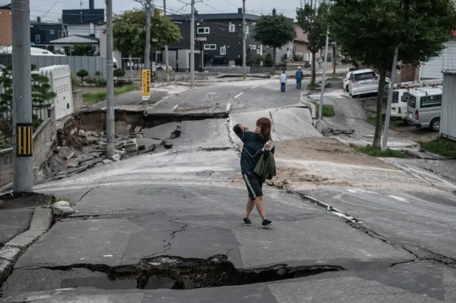 يابانية تسير في طريق دمره زلزال في جزيرة هوكايدو شمالي البلاد