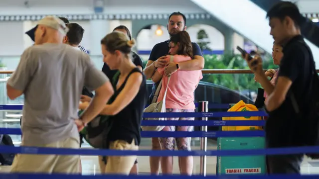 Los pasajeros varados hacen cola en el servicio de atención al cliente de Qatar Airways en el Aeropuerto Internacional I Gusti Ngurah Rai en Indonesia después de que se cancelaran los vuelos a Doha, Dubái y Abu Dabi tras los ataques contra Irán lanzados por Estados Unidos e Israel.