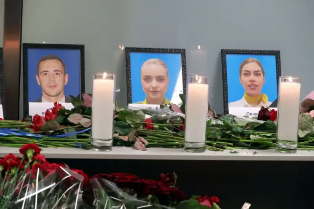 Свічки і квіти біля портретів загиблих бортпровіднкиів
