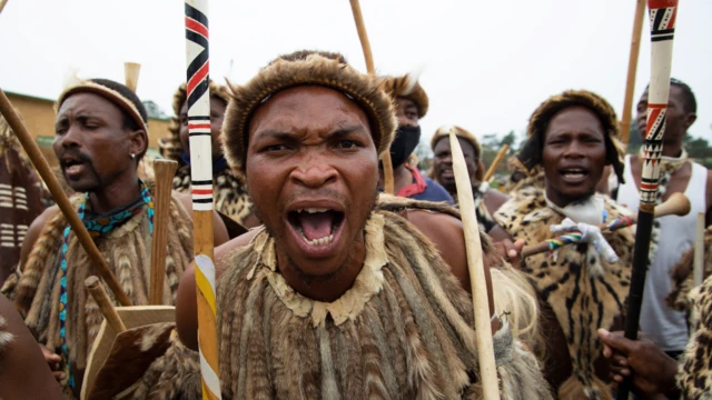 Zulu men wear traditional warrior outfits at night for Nongoma, South Africa - March 2021