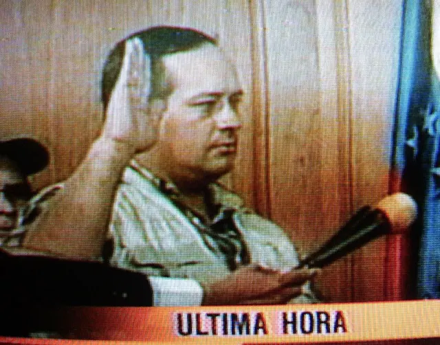 Cabello levanta el brazo derecho en señal de juramento y, ante un micrófono, jura el cargo. Debajo aparece un cintillo televisión con el anuncio de "Última hora". 