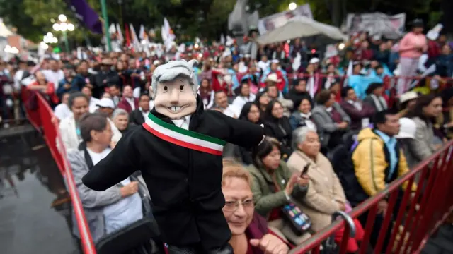 Boneco representando López Obrador, segurado por uma apoiadora do candidatopixbet twitterum comício no México