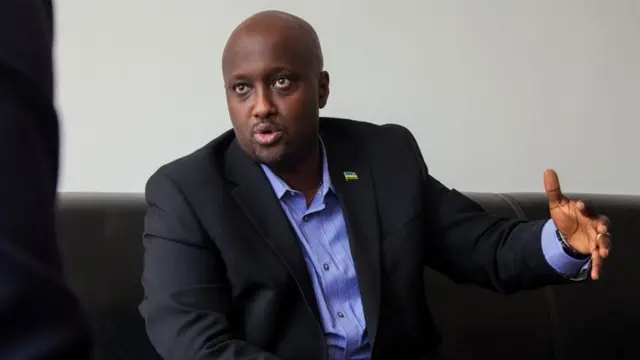Minisitiri w'ububanyi n'amahanga w'u Rwanda, Olivier Nduhungirehe mu ikoti ryirabura n'ishati y'ubururu ifunguye mw'ijosi