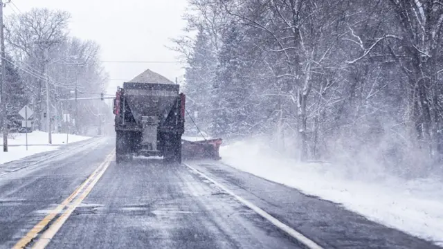 Camión lanzando sal en una calle congelada