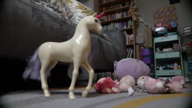 Juguetes de niños, incluido un unicornio, se encuentran esparcidos en el suelo del dormitorio de un niño.