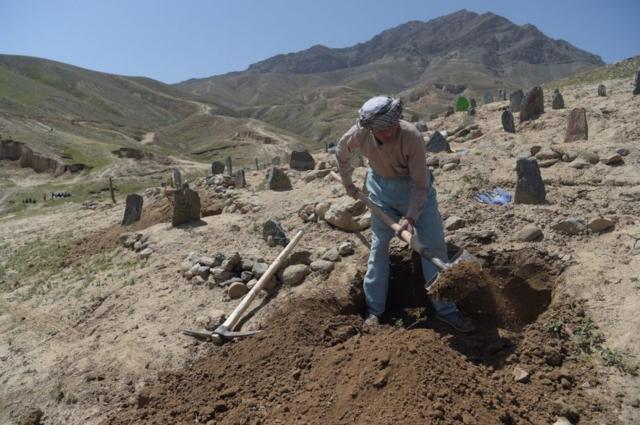 An Afghan man digs a grave, 2018