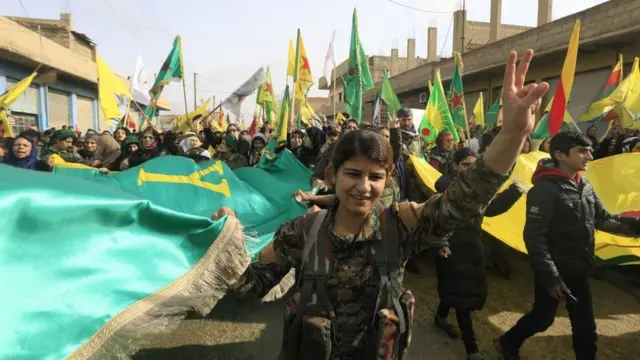 Бойцы курдских отрядов самообороны на демонстрации в сирийском городе Амуда