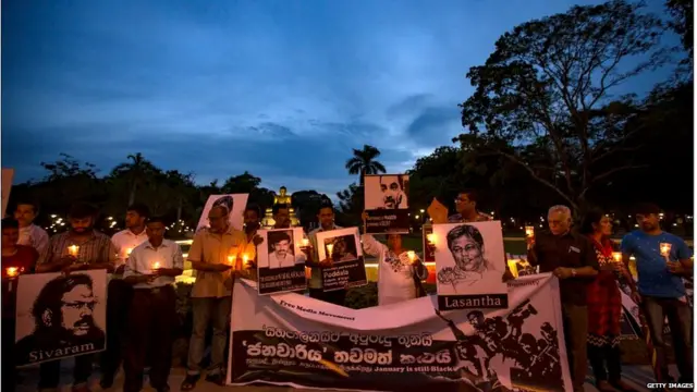 Wife of missing Sri Lankan cartoonist Prageeth Eknaligoda, Sandhya Eknaligoda and media activists engage in a silent protest by holding photos of slain journalists while holding candles at the "Black January" vigil to commemorate the disappeared,abducted and killed Sri Lankan journalists in Colombo, Sri Lanka January 30, 2018