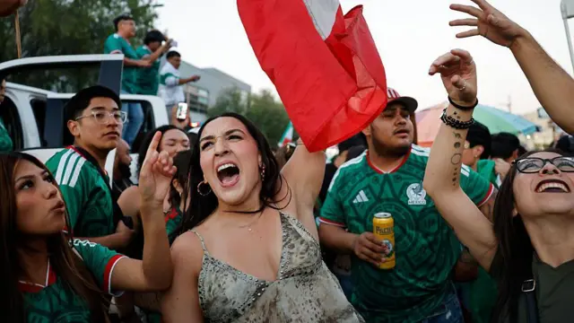 Mexicanos con la bandera celebran el triunfo de su selección.