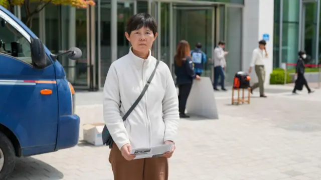 흰색 플리스 재킷을 입은 박미숙 씨가 건물 밖에 서 있다.