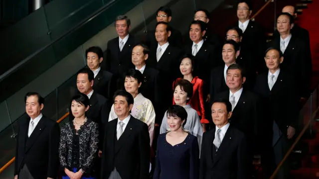 টোকিওতে প্রধানমন্ত্রীর সরকারি বাসভবনে শিনজো আবে তার নতুন মন্ত্রিসভার সদস্যদের সাথে একটি গ্রুপ ছবির জন্য পোজ দিচ্ছেন