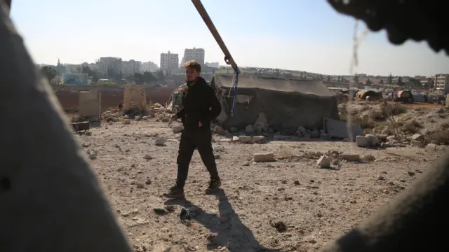 رجل يتفقد الأضرار بعد غارة جوية على مخيم للاجئين في حي الجامعة في مدينة إدلب، شمال سوريا،