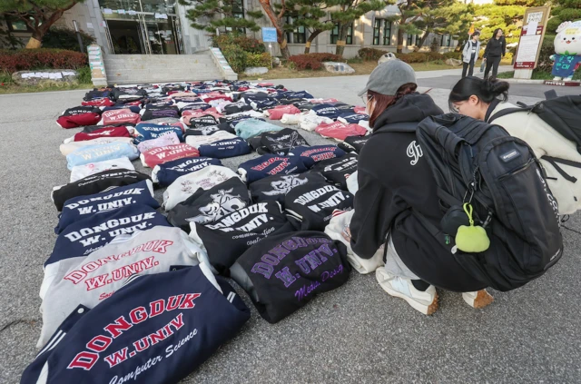 동덕여대 학생 두 명이 학교 측의 남녀공학 전환 추진에 반발하는 학생들이 항의의 의미로 학교 점퍼(과잠)을 본관 앞에 벗어놓고 있다