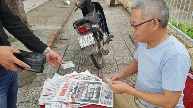 Nhà báo Lê Đức Dục bán báo Tuổi Trẻ trên vỉa hè vào năm 2018
