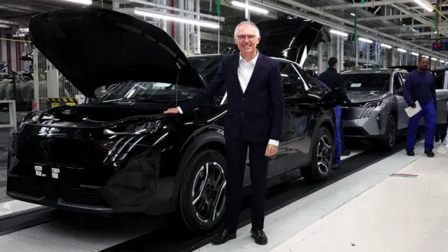 کارلوس تاوارش در کنار یک دستگاه پژو در خط تولید این کارخانه